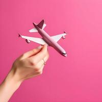 AI generated Hand Holding White Model Airplane on Pink Background photo