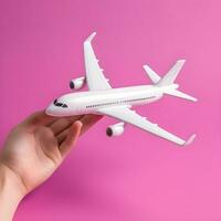 AI generated Hand Holding White Model Airplane on Pink Background photo