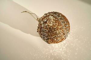 Shiny Christmas ball of gold color on a white background. photo