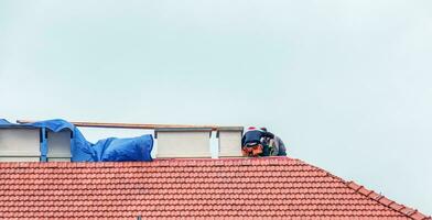 Nitra, Slovakia - 05.15.2023 Handymen repair chimneys on the roof of a house. photo