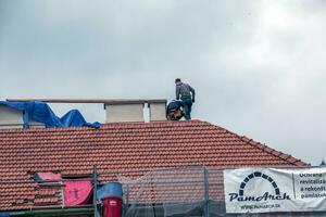 Nitra, Slovakia - 05.15.2023 Handymen repair chimneys on the roof of a house. photo