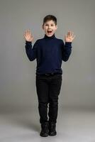Nice schoolboy is posing at studio over a gray background. photo