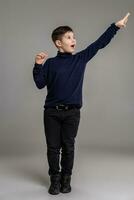 Nice schoolboy is posing at studio over a gray background. photo
