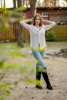 Teenage girl standing in courtyard of country villa, enjoying free time in spring photo