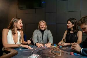 Smiling man raking pile of chips after successful poker game in casino photo