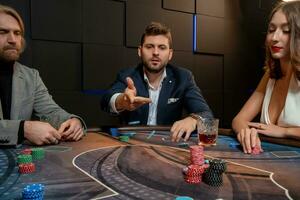 Focused interested young bearded man playing poker in casino photo