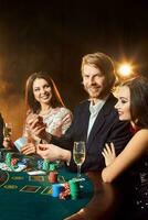 Group of young rich people is playing poker in the casino photo