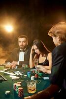 grupo de joven Rico personas es jugando póker en el casino foto