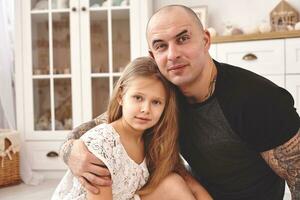 Adorable daughter wearing a white dress whith her loving father in a modern kid's room whith a wooden furniture. Happy family. photo