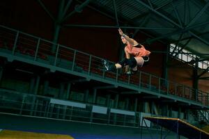 The young woman performs a trick. Jump. Indoor training photo