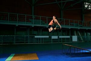 The young woman performs a trick. Jump. Indoor training photo