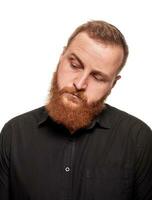 Portrait of a young, chubby, redheaded man in a black shirt making faces at the camera, isolated on a white background photo