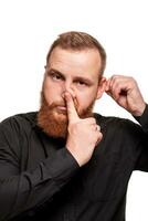 Portrait of a young, chubby, redheaded man in a black shirt making faces at the camera, isolated on a white background photo