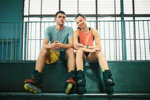 Young man and woman having fun on roller skates in skate park. Hobby photo