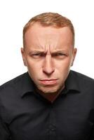 Portrait of young man questionably mistrustfully looking with lowered eyebrows on white background. photo