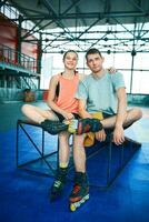Girl and boy on rollerblades in skate park photo