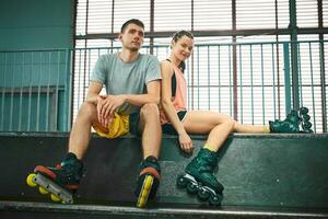 Young man and woman having fun on roller skates in skate park. Hobby photo