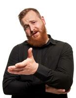 Portrait of a young, chubby, redheaded man in a black shirt making faces at the camera, isolated on a white background photo