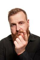 Portrait of a young, chubby, redheaded man in a black shirt making faces at the camera, isolated on a white background photo