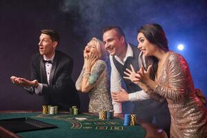 grupo de un elegante Rico amigos son jugando póker a casino. foto