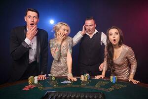 Group of a stylish rich friends are playing poker at casino. photo