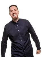 Portrait of a handsome, unshaven man, dressed in a dark blue shirt, standing against a white background. Self confident man. photo