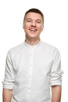Portrait of young man in casual shirt smiling while standing against white background photo