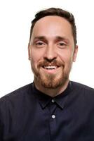 Portrait of a handsome, unshaven man, dressed in a dark blue shirt, standing against a white background. Self confident man. photo