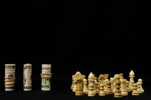 a group of wooden chess pieces and money photo