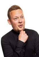 Close up portrait of a confident, blond, handsome young man wearing black shirt, isolated on white background photo