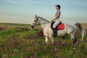 amazona jockey en uniforme montando caballo al aire libre foto