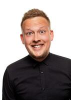 Close up portrait of a confident, blond, handsome young man wearing black shirt, isolated on white background photo