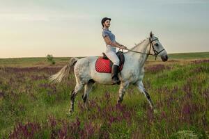 Horsewoman jockey in uniform riding horse outdoors photo