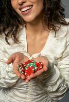 rojo y verde apuesta tokens en palmas de riendo joven mujer foto