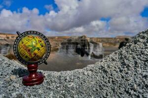 a globe on top of a rocky cliff photo