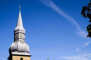 un Iglesia campanario en contra un azul cielo foto