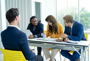 Job interview concept. Diverse hr team doing job interview with a man in business office. Human resources team interviewing a potential job candidate. Hiring, employment, and recruitment concept. photo