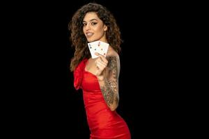 Smiling gambling young woman holding winning set of two aces photo