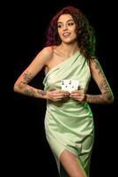 Smiling gambling young woman holding winning set of two aces photo