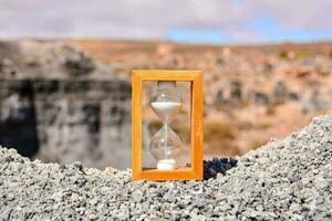 an hourglass on a rocky cliff photo