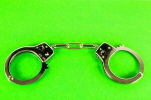handcuffs on a green background photo