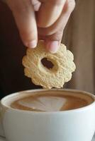 pouring sweet cookies in a coffee mug on wooden table photo