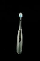 an electric toothbrush with a silver handle photo