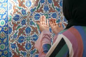 Muslim young woman in hijab is praying in mosque. photo