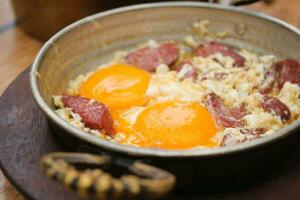 Fried eggs with sucuk or sausage in a pan photo