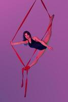 hermosa niña en un negro traje de baño es ejecutando un acrobático elementos en estudio. foto