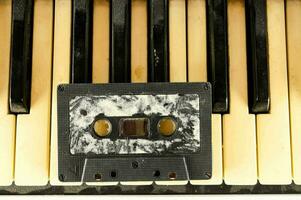 an old cassette is sitting on top of piano keys photo