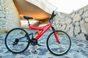 a red bicycle parked on a stone path photo