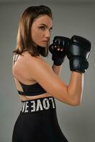 Athletic woman in boxing gloves is practicing karate in studio. photo