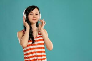 Studio photo of a gorgeous girl teenager posing over a blue background.